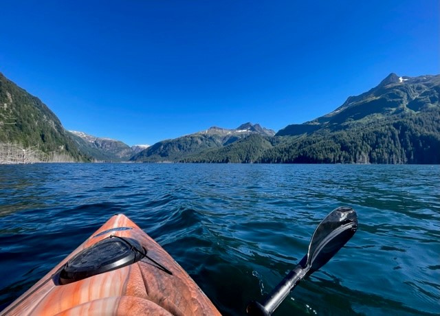 A kayak rests on blue water within the Tongass near Sitka.